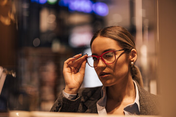 Close up of a woman holding glasses with dioptry, trying on.