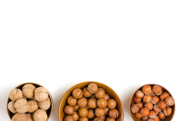 natural organic macadamia, walnut, hazelnut nuts in wooden bowl on white background Flat lay Top view Healthy snack Nuts with essential oil rich in vitamins B, PP, lot of fats and high in calories 