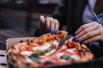 Close up of female hands, getting ready to eat pizza.