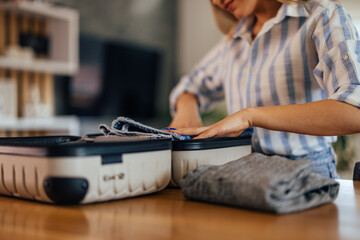 Young girl, putting clothes into the mini coffer.