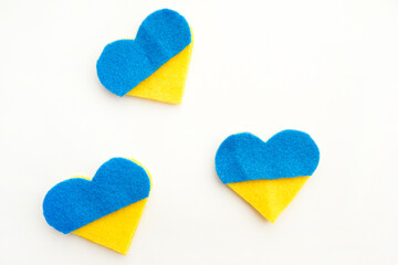Ukraine flag theme. Heart shape  of  blue and yellow made of felt on white background. Topical...