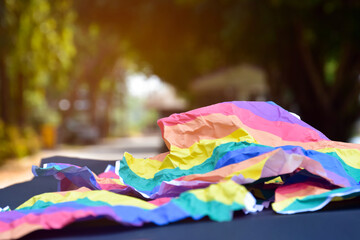 Closeup view of a wrinkled sheet of rainbow paper which was left by the side of the road. concept for lgbt celebrations in pride month, soft and selective focus.