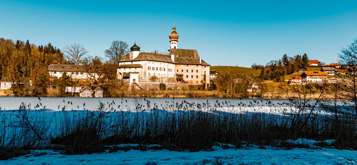 Beautiful winter wonderland with a monastery at the famous Hoeglwoerther See lake, Hoeglwoerth, Bavaria, Germany