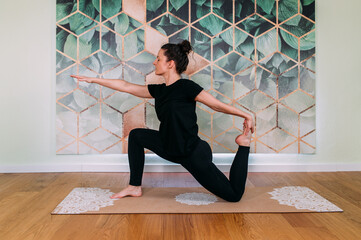 sportliche Frau in schwarz macht Yoga im Studio horizontal