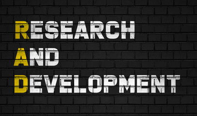 Research and development (RAD) concept,business abbreviations on black wall 