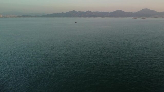 Sea air view. Several boats in the sea. Mountains on the background of the sea. White haze
