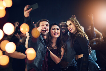 One more just because we can. Cropped shot of a diverse group of young friends taking a selfie together at a party at night.