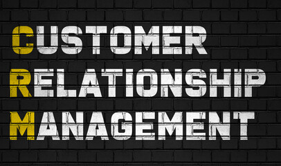 Customer relationship management (CRM) concept,business abbreviations on black wall 