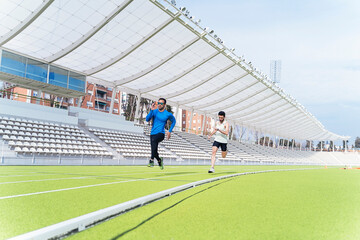 Two friends jogging on a track.
