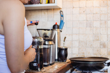 back view of woman preparing coffee in the kitchen with copy space on the right
