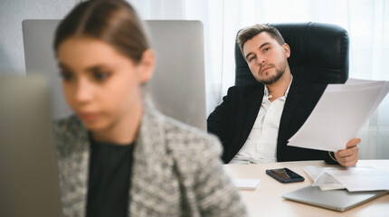 Young attractive woman and adult man are working in the office. Open space concept for teamwork