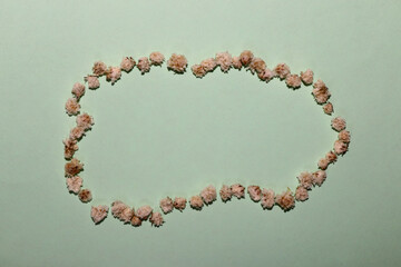 a cloud of small flowers on a pastel blue background in a cloud of empty copy space