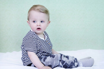 Fototapeta premium Defocused child opened his mouth and looks up in surprise. Background for sales. Copy space for your text - concept for baby products, shocking news, amazement, childhood