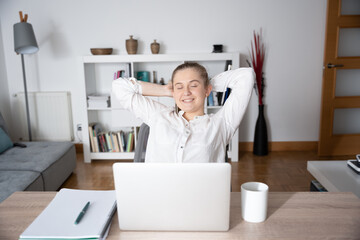 Relaxed woman working from home in front of laptop.
