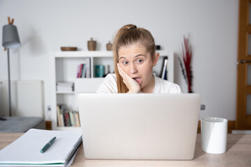 Surprised scandinavian woman in front of laptop