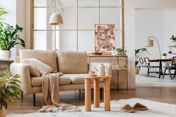 Modern living room interior composition with beige sofa, wooden coffee table, painting and creative home accessories. Template. Copy space. Dining room in the background.