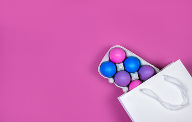 Banner on a pink background. The concept of online shopping for Easter, purchases and sale for the holiday. Gift bag with Easter eggs.