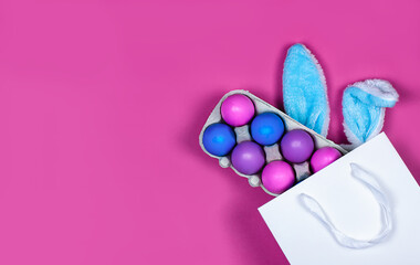 Banner on a pink background. The concept of online shopping for Easter, purchases and sale for the holiday. Gift bag with bunny ears and Easter eggs