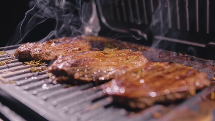 Delicious juicy meat steak cooking on grill. Aged prime rare roast grilling tenderloin fresh marble tenderness beef. Prime beef fry on electric roaster, rosemary, black pepper, salt. Slow motion.