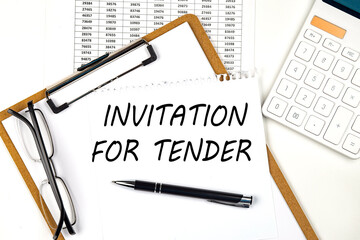 Text INVITATION FOR TENDER on the white paper on clipboard with chart and calculator