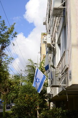Fototapeta na wymiar Residential building in the old district of Tel Aviv. Israel flag and kumquat tree with fruits.