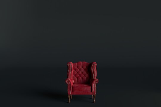 Red velvet armchair of old design on short legs with high back isolated on black background.