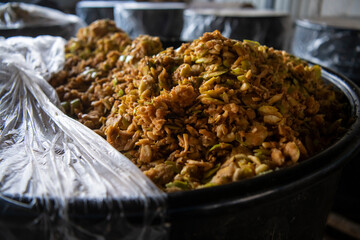 Closeup of cauldron or barrel full of mashed or chopped apple fruit, in process of fermenting grounded fruit for distillation and making traditional alcohol drink rakija (brandy).  