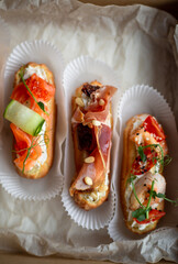 Eclairs with salmon, fresh vegetables and herbs, gourmet snacks.