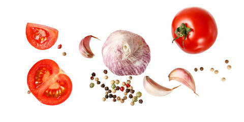 Aromatic spice card. Garlic, sliced tomatoes and red black peppers flying isolated on white...