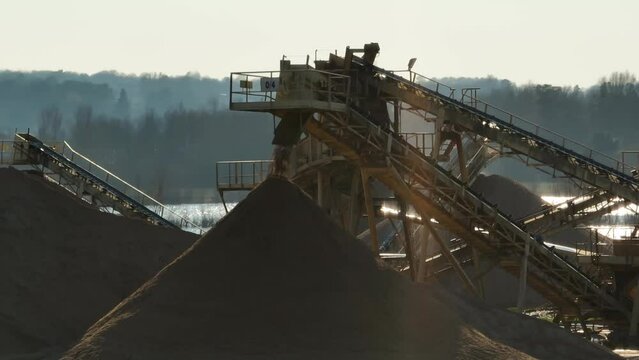Aerial shot of machines and trucks working in a sand quarry, in France. Those are extracting and  filtering the sand.
