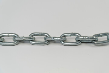 Silver chain laid on the ground with isolated on white background, iron chain straight line on the platform, front view