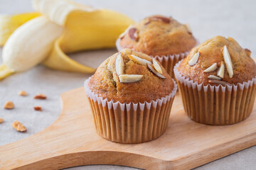 Banana muffins with almond on wooden board