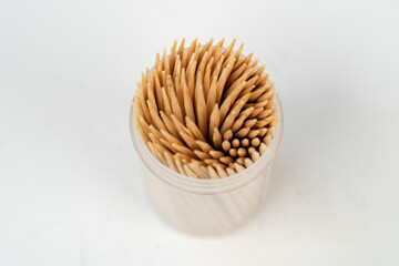 Toothpicks in a small cylindrical box isolated on white background, too much dental pick top view