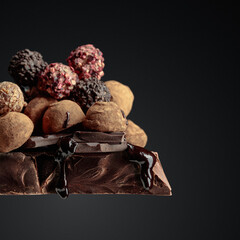 Chocolate truffles on a large piece of dark chocolate.