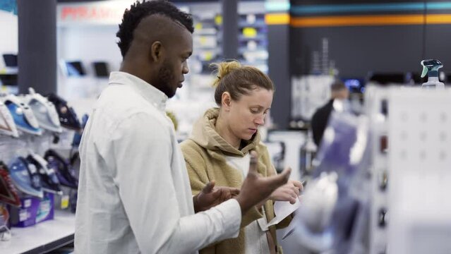 Shop assistant giving advice to woman in store