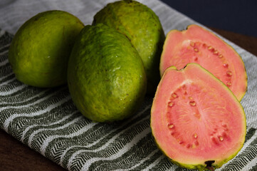 Halved red guava and whole green guavas