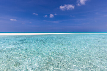 Closeup sandy beach waves and blue summer sky. Panoramic beach landscape. Empty tropical beach and seascape. Bright blue sky, soft sand, calmness, tranquil relaxing sunlight, summer mood