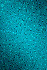 Wet with water drops dark turquoise background with gradient illumination at two corners, macro
