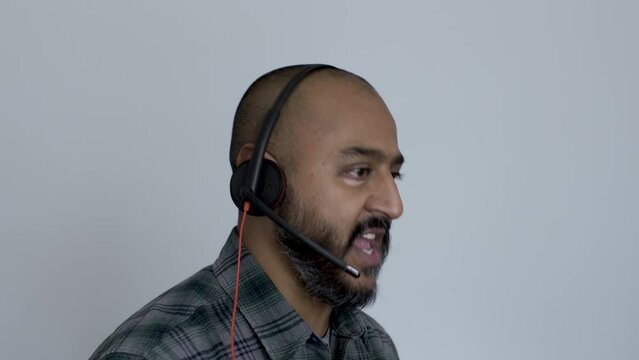 A Close Up Shot Of An Asian Telesalesman Clarifying The Benefits Of His Product While Talking To A Customer, The Man Running Through His Sales Pitch With Animated Facial Expressions And Actions