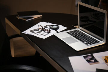 Workplace of FBI agent with laptop in office at night