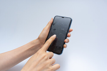 Smartphone with badly damaged screen on a white background