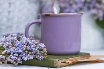 The postcard is beautiful. A fancy purple coffee mug, an old book and a bouquet of purple lilac....