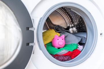Concept of saving electricity with a washing machine with a piggy bank inside