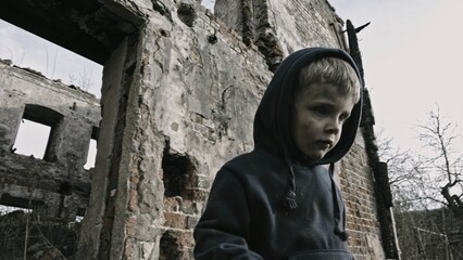 Child playing war in ruins 