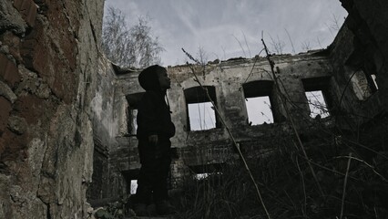 Child playing war in ruins 