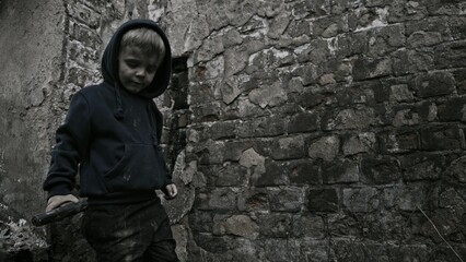 Fototapeta na wymiar Child playing war in ruins 