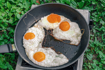 Scrambled eggs in a frying pan. Snack in nature. Appetizing food. Top view.