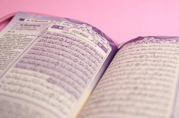 Fototapeta premium Muslim Al-Quran with Indonesian translation on pink background