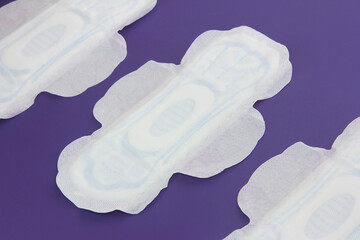 women's white sanitary pads for menstruation on a purple background very peri