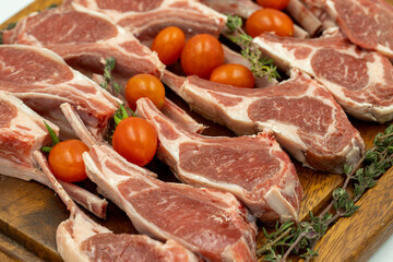Lamb chops on dark background. Raw lamb chops on wood serving board. Close up